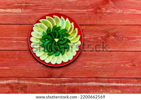 Beautifully decorated slices of fresh orange, lemon on a round plate. green kiwi.  Lime. on a wooden background. the concept of the holiday.  valentine's day. space for text. Still-life