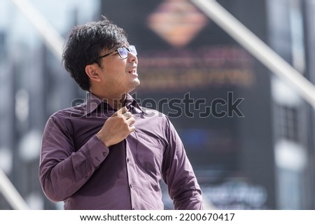 Asian guy in  with purple tshirt feeling hot weather Royalty-Free Stock Photo #2200670417