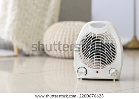 Electric fan heater on floor in living room Royalty-Free Stock Photo #2200676623