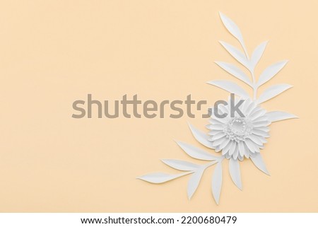 Paper flower with leaves on beige background