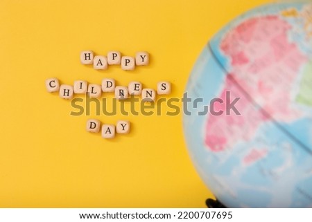 Universal children's day, inscription children's day on a yellow background, with a globe.