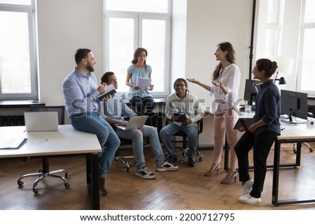 Happy company mentor woman training interns in office, motivating new employees. Female business leader talking to team, presenting ideas, brainstorming on project Royalty-Free Stock Photo #2200712795