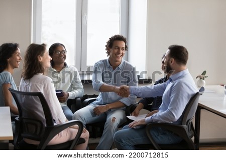 Happy coworkers shaking hands, expressing recognition, acknowledgement, gratitude, congrats on success. Cheerful group mate giving handshake on therapy meeting, smiling, laughing Royalty-Free Stock Photo #2200712815