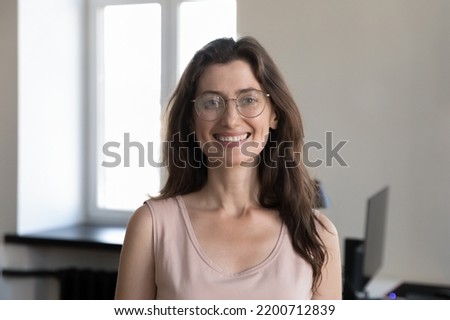 Happy pretty young business professional woman in glasses head shot portrait. Millennial entrepreneur, female leader, employee in casual looking at camera, smiling, posing in office