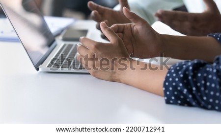 Hands of male and female office employees sitting at work table, talking at laptop computer, gesturing, discussing project. Banner, cropped shot, close up. Business communication concept Royalty-Free Stock Photo #2200712941
