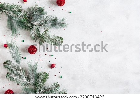 Christmas composition. Fir tree branches, red decorations on gray background. Christmas, winter, new year concept. Flat lay, top view, copy space