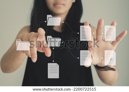 Asian woman working on virtual display monitor showing document management system (DMS), online document database and process automation to enhance efficiency of file management. Business concept