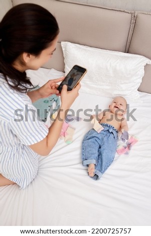 Mother takes pictures of baby by smartphone