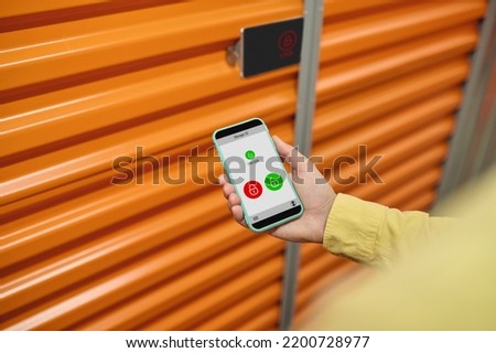Authorized worker opening the warehouse digital lock with his smartphone