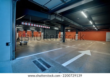 Spacious well-lit underground garage in the warehouse facility Royalty-Free Stock Photo #2200729139