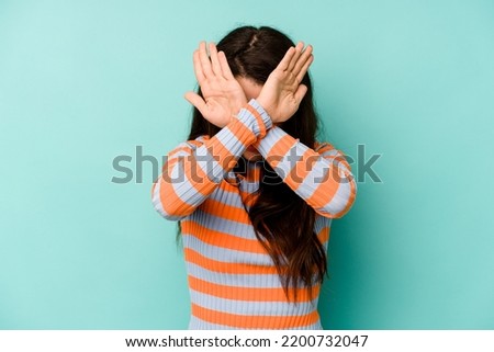 Young caucasian woman isolated on blue background keeping two arms crossed, denial concept. Royalty-Free Stock Photo #2200732047