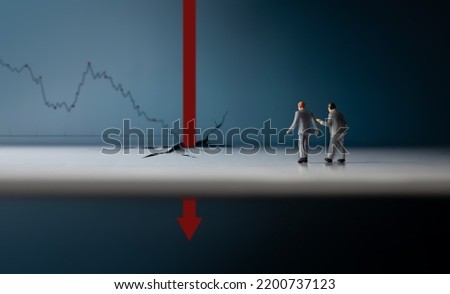 Recession, Inflation and Depression Concepts. Economic Crisis. Graph Fall Down, Business Collapse. Two Miniature Figure of Businessman Looking at a Red Graph Arrow Falling Deep Down Royalty-Free Stock Photo #2200737123