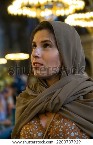 Young veiled woman visiting the interior of the Hagia Sophia mosque.