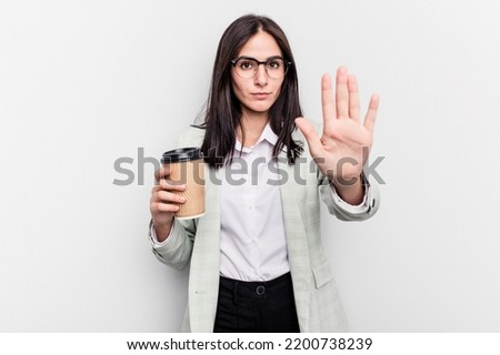 Young business caucasian woman holding takeaway coffee isolated on white background standing with outstretched hand showing stop sign, preventing you.