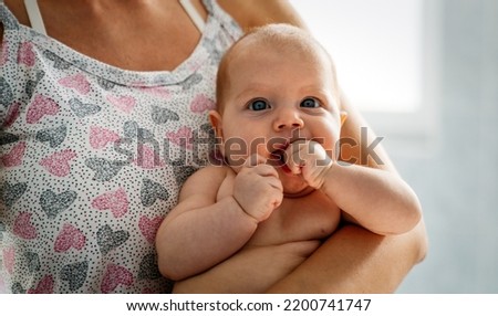 Young tender happy mother hugging her newborn baby smiling