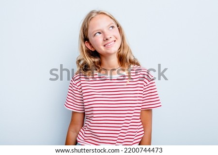 Caucasian teen girl isolated on blue background relaxed and happy laughing, neck stretched showing teeth.
