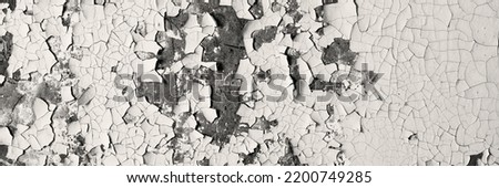 Peeling paint on the wall. Panorama of a concrete wall with old cracked flaking paint. Weathered rough painted surface with patterns of cracks and peeling. Wide panoramic texture for grunge background Royalty-Free Stock Photo #2200749285
