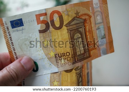 my thumb and two fifty euro banknotes to pay for goods in the supermarket