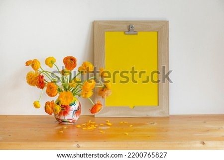  Vertical frame and an orange ranunculus flowers on the vintage table, cozy home decor, and design for mockup creations, Empty wooden frame with Persian buttercup flowers, 