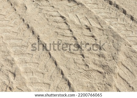marks of a huge digger in the sand of the construction site
