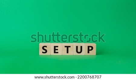 Setup symbol. Wooden cubes with word Setup. Beautiful green background. Setup concept. Copy space.