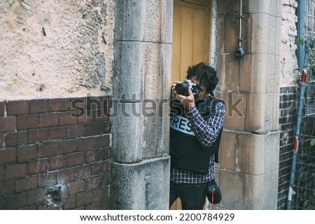 Press photographer, wearing a bulletproof vest	 Royalty-Free Stock Photo #2200784929