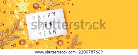 Happy New Year. Banner with lightbox and golden decorations on a yellow background.