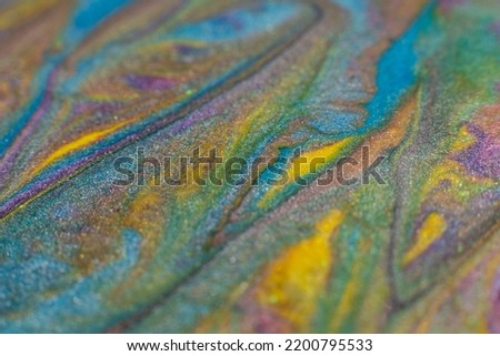 Glitter art. Abstract design. Colorful paint background. Green blue yellow colors blend.