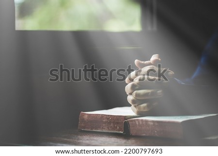 Hand folded in prayer to god on Holy Bible book in church concept for faith, spirituality and religion, woman person praying on holy bible in morning. christian catholic woman hand with Bible worship. Royalty-Free Stock Photo #2200797693