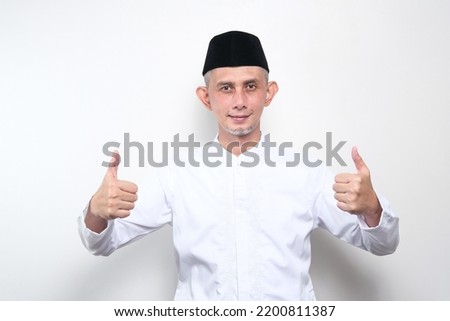 Portrait of Asian Moslem Man with doing positive gesture with hand, thumbs up, ok sign

