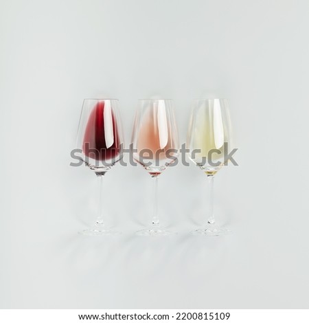 Flat-lay of red, rose and white wine in glasses on white background. Wine bar, winery, wine degustation concept. Minimalistic trendy photography. Square composition