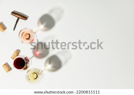 Flat-lay of red, rose and white wine in glasses on white background. Wine bar, winery, wine degustation concept. Minimalistic trendy photography. Copy space
