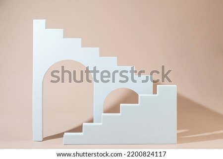 Geometric shapes stairs podiums and archs standing on a beige background Royalty-Free Stock Photo #2200824117