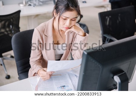 A businesswoman is sitting at his desk showing stress from the company's problems.