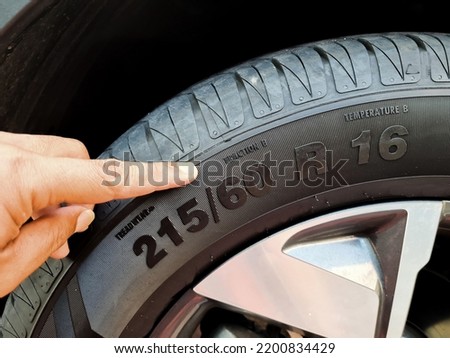Side view of the tire with the indication of the width of the tire, the height and diameter of the wheel. tire code that includes the temperature code, speed limit and expiration date of the tire and Royalty-Free Stock Photo #2200834429
