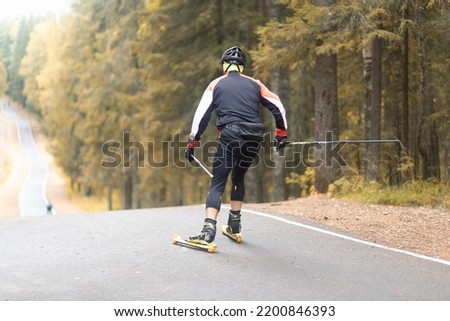 Cross country skilling.A man on roller skis rides in the autumn park.