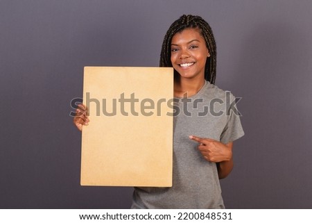 Young brazilian woman holding sign for text or announcement. advertising photo.