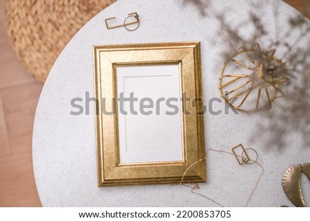 mockup gold photo frame on white stone round table with sunlight