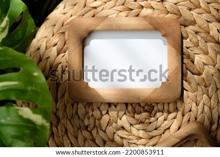 mockup wood photo frame on wicker stood with monstera with sunlight