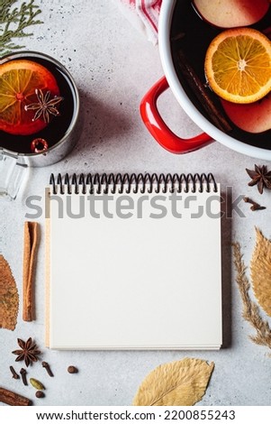 Autumn background with notepad, mulled wine and dry leaves, mock up, copy space, flat lay.