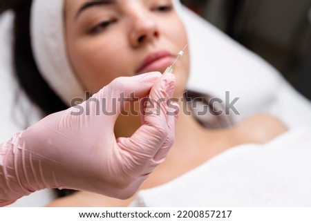 Face lifting PDO Suture operation. innovative technique of New thread lift, cosmetologist preparing to do procedure to female client, select the appropriate thread option Royalty-Free Stock Photo #2200857217