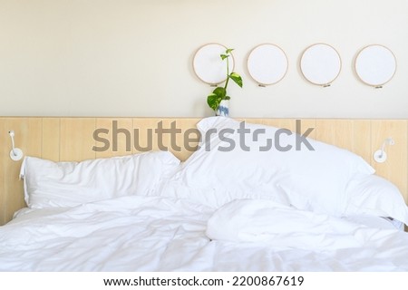 White bedding with plant decoration in minimal hotel room.