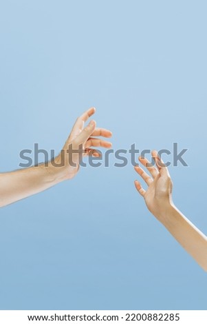 Male and female hands greeting each other isolated on blue background. Concept of relationship, feelings, community, care, support, symbolism, art. Copy space for ad
