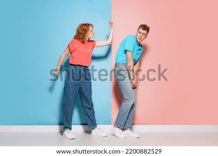 Portrait of young couple, woman quarreling man isolated over pink blue studio background. Misunderstanding. Concept of youth, emotions, facial expression, love, relationship. Poster, ad