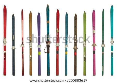 Row of vintage weathered colorful skis isolated on a white background