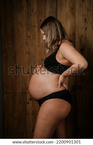 Portrait young pregnant woman touching her belly 