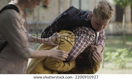 Two strong boys bullies beating weak junior school boy, physical abuse problem Royalty-Free Stock Photo #2200910927