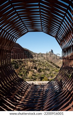 Roque bentayga seen through a sculpture representing a basket. The Nublo Rural Park. Tejeda. Gran Canaria. Canary Islands. Spain. Royalty-Free Stock Photo #2200916001