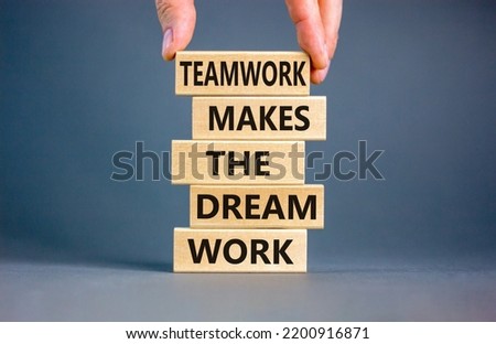 Teamwork makes dream work symbol. Concept words Teamwork makes the dream work on wooden blocks on a beautiful grey background. Businessman hand. Business Teamwork makes dream work concept. Copy space.