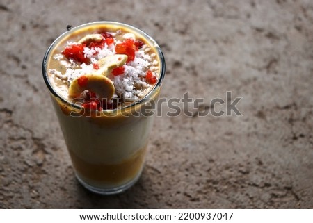 Authentic Indian cold drink made up of curd, rabidi and ice called lassi on cement background.
